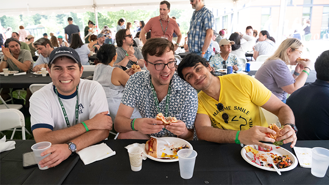 Three reunions attendees posing for a photo, seated at a table enjoying lunch.