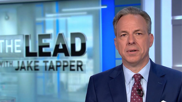 Jake Tapper sitting in a newsroom.