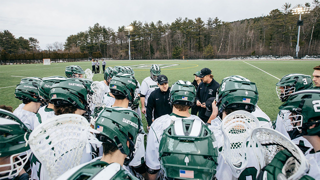 Lacrosse coach talking to players on the side of the field
